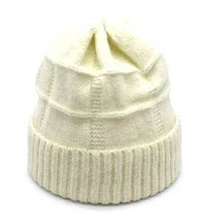 Close-up of thick ribbed knit texture and folded hem on an off-white wool beanie