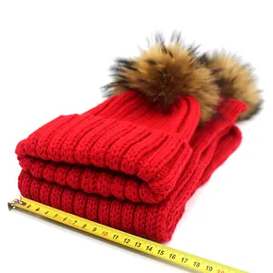Detail view of red knit scarf being measured showing its width of 18cm on white background