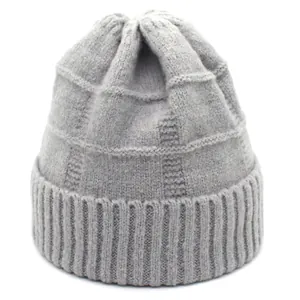 Detail of grey knitted winter hat featuring checkered texture and ribbed elastic cuff