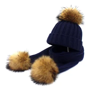 Navy blue knitted winter set featuring a beanie hat and scarf with fluffy faux fur pom-poms