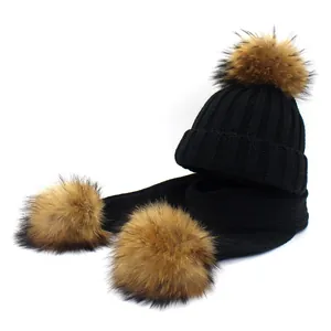 Close-up of black ribbed knit winter set featuring three plush faux fur pom-poms on hat and scarf