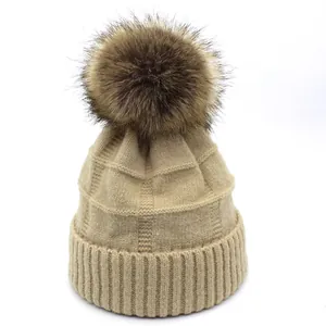 Detailed knit texture and brown faux fur pom-pom on this beige winter wool beanie hat