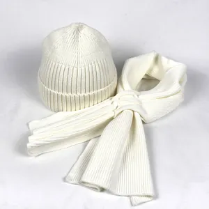 Detail of cream white ribbed knit beanie and scarf set showing warm textile texture