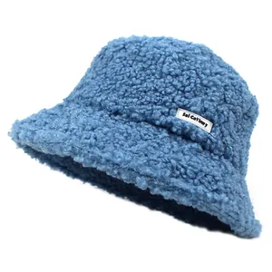 Detail shot of the soft teddy fleece texture and side label on a blue bucket hat