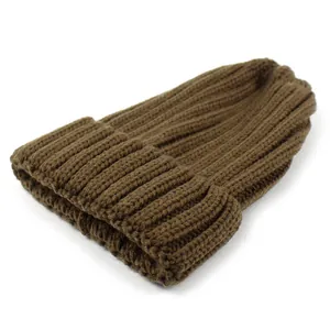 Détail de la maille épaisse d'un bonnet marron foncé avec large bord plié pour l'hiver