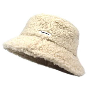 Detailed texture of off-white faux shearling bucket hat with Sol Carina Y logo patch