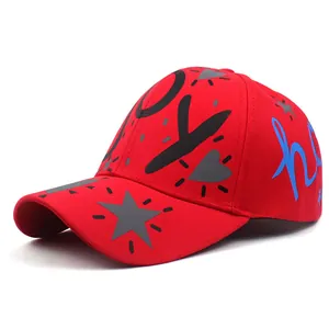 Detailed view of red cotton twill baseball cap with black and blue graffiti patterns