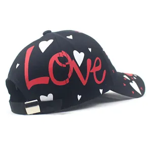 Black cotton baseball cap with red Love graffiti and heart patterns shown from side view