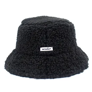 Stylish black teddy faux fur bucket hat with embroidered letter patch for winter warmth