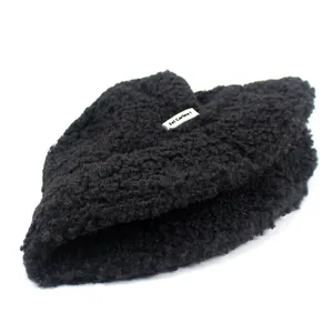 Women's black faux shearling bucket hat with warm teddy fleece texture and side logo patch