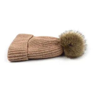 Warme camelkleurige gebreide damesmuts met imitatiebont pompon en ribgebreid