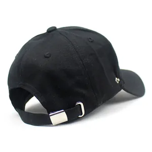 Detail view of adjustable metal buckle and breathable eyelet on black cotton baseball cap