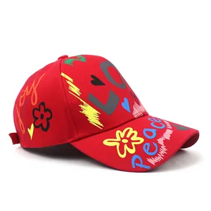 Dettaglio del cappello rosso in cotone con graffiti LOVE e ricami peace colorati