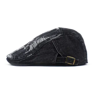 Detail of black washed denim beret featuring vintage distressed frayed holes and metal buckle