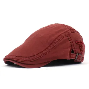 Détail d'un béret en coton bordeaux avec broderie latérale et boucle en métal réglable