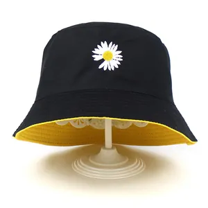 Détail de la broderie marguerite et doublure jaune sur chapeau bob noir en coton
