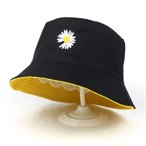 Détail de la broderie marguerite sur le chapeau bob réversible noir et jaune en coton