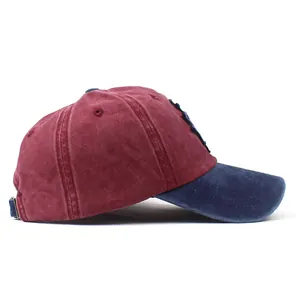 Close-up of washed cotton baseball cap with burgundy crown and navy blue brim detail