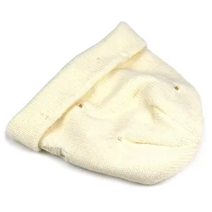 Close-up detail of cream white ribbed knit beanie with stylish distressed hole design