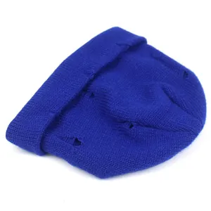 Close-up of royal blue knitted beanie with distressed ripped details and soft texture