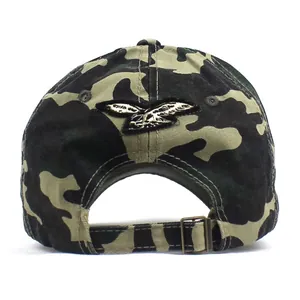Détail de la casquette camouflage avec broderie d'aigle dorée et boucle de réglage en métal