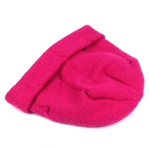 Close-up of rose red ribbed knit beanie featuring stylish distressed hole details