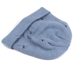 Close-up of distressed knit beanie in misty blue showing soft wool texture and ripped detail