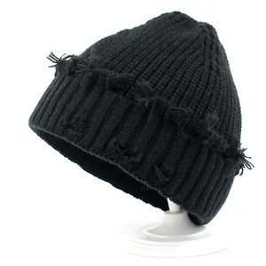 Distressed black ribbed knit beanie with vintage ripped details for winter fashion