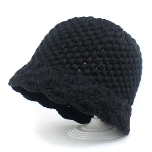 Black chunky knit bucket hat for women featuring a textured crochet design on a white stand
