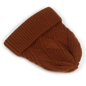 Details einer karamellfarbenen Strickmütze mit Rautenmuster und geripptem Saum