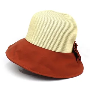 Détail d'un chapeau de soleil en paille avec bord en tissu et décoration florale élégante