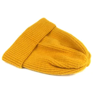 Detail of chunky ribbed knit texture on a yellow winter beanie hat with folded cuff