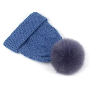 Detailansicht der dunkelblauen Strickmütze mit flauschigem Kunstpelz-Pompon und Rippstrick