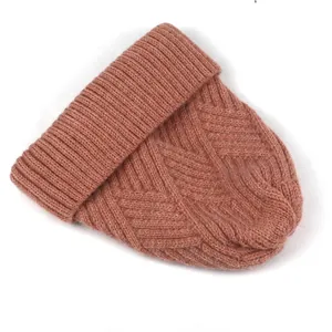 Details des Zopfmusters und Rippbündchens an einer staubrosa Winter-Strickmütze