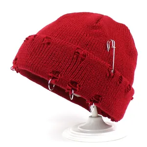 Red distressed knit beanie with silver rings and safety pin for a street punk style look