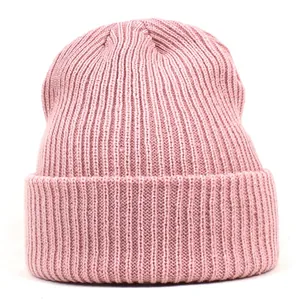 Close-up of light pink acrylic knitted beanie with fine rib texture and cuff detail
