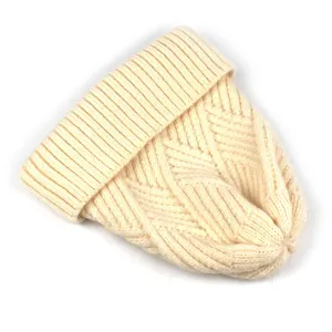 Detailaufnahme der cremefarbenen Strickmütze mit Rautenmuster und geripptem Umschlag