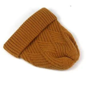 Detail der groben Zopfstrickstruktur einer senfgelben Beanie mit Rautenmuster