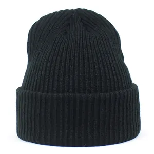Close-up of black ribbed knit beanie showing thick acrylic yarn texture and folded cuff