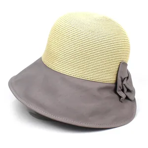 Détail d'un chapeau de paille à larges bords bicolore avec un élégant nœud décoratif