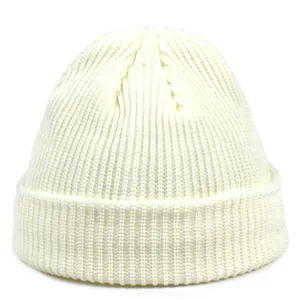 Close-up of ivory acrylic knit beanie showing thick ribbed texture and wide folded cuff