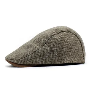Detail view of brown herringbone wool newsboy cap with classic vintage textured fabric