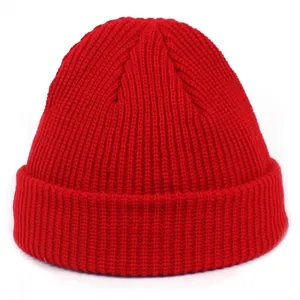 Detailed view of red knitted beanie featuring a wide cuff and thick ribbed texture