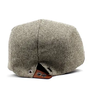 Classic grey herringbone flat cap featuring brown leather detail and metal snap buttons