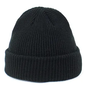 Close-up of the black ribbed knit texture and folded cuff on the warm acrylic beanie