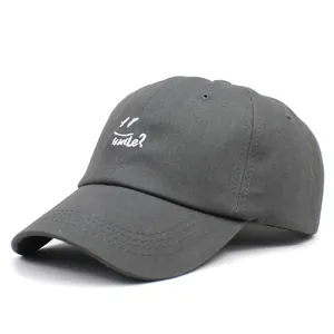 Detailed close-up of white smile embroidery on a dark grey cotton baseball cap