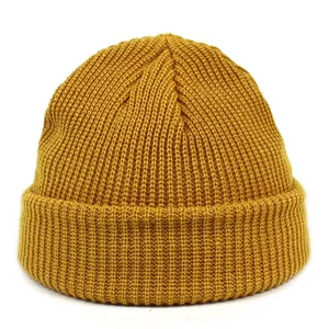Close-up of mustard yellow ribbed knit beanie with fold-over cuff texture detail