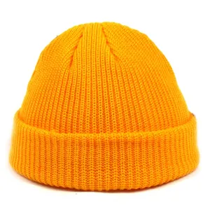 Close-up of bright orange acrylic knit beanie showing detailed vertical ribbing texture