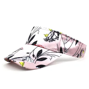 Macro shot of pink satin sun visor with floral print and wide brim for sun protection