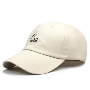 Close-up of smile embroidery on light beige cotton twill baseball cap with curved brim